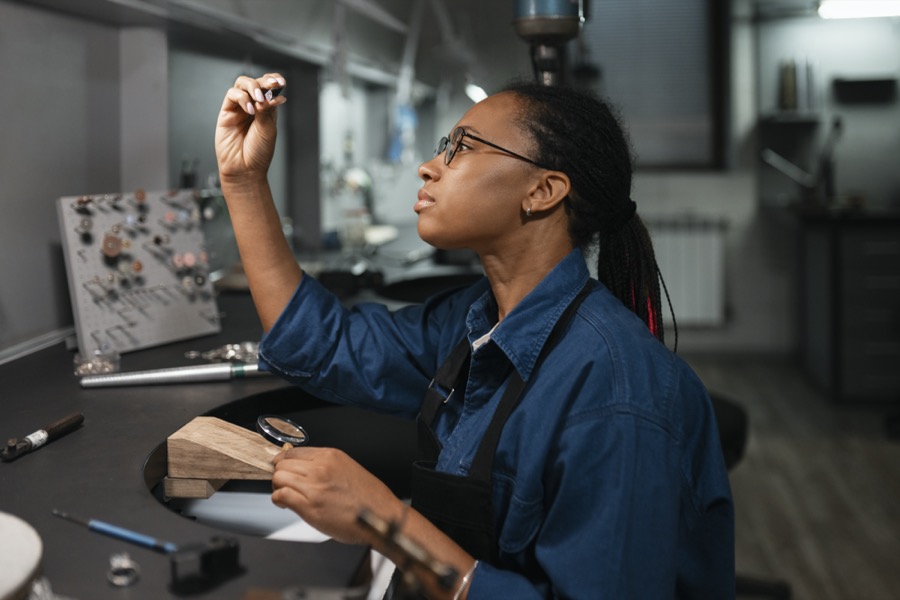 Técnica examinando una pieza en su puesto de trabajo